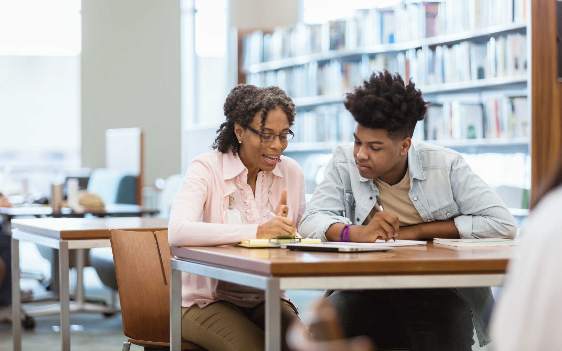 A retirement-age teacher helps a student